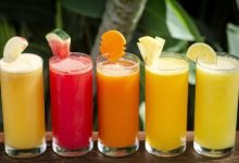 mixed fresh organic fruit juice glasses selection on sunny garden table photo