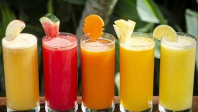 mixed fresh organic fruit juice glasses selection on sunny garden table photo