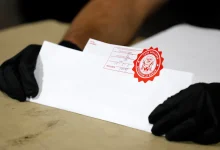 Election workers check the tapes