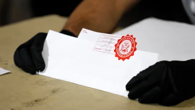 Election workers check the tapes